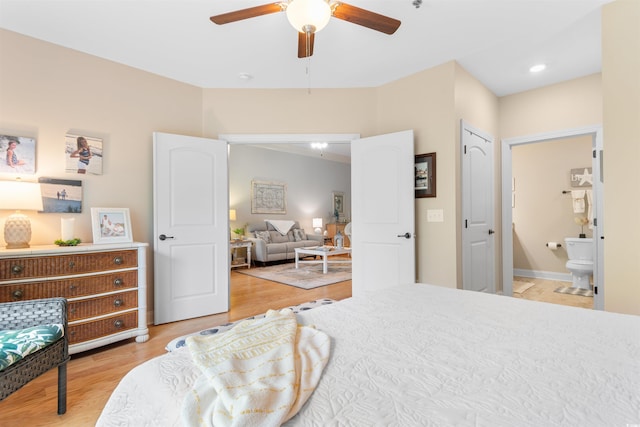 bedroom featuring light wood finished floors, connected bathroom, and ceiling fan