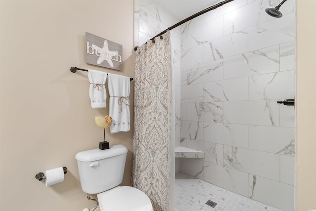 bathroom featuring a tile shower and toilet