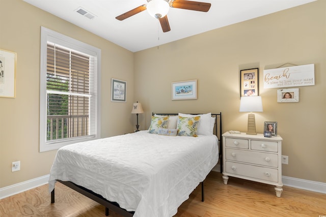 bedroom with baseboards, wood finished floors, and a ceiling fan