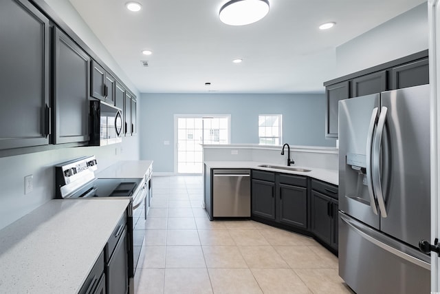 1031 Snowberry Dr, Longs, SC 29568 - kitchen with stainless steel appliances, a sink, a peninsula, light tile patterned floors, and recessed lighting
