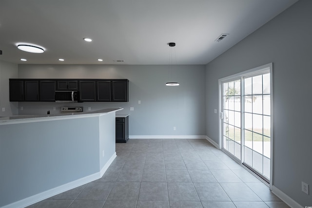 1031 Snowberry Dr, Longs, SC 29568 - kitchen with stainless steel microwave, recessed lighting, light countertops, baseboards, and stove
