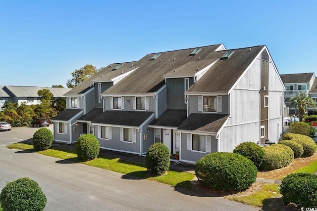 view of front of house with a residential view and roof with shingles