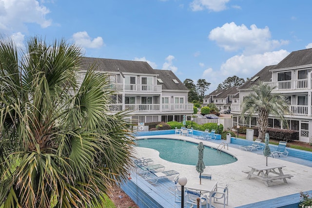 community pool featuring a residential view and a patio
