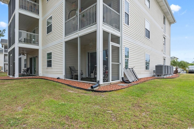 rear view of house featuring a yard and central AC