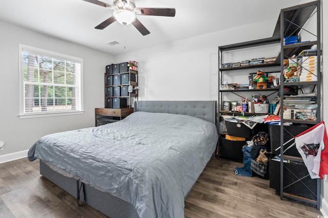 bedroom featuring wood finished floors, baseboards, and a ceiling fan