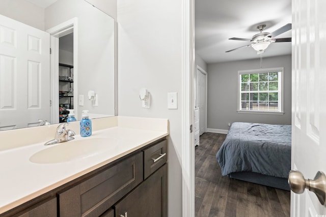 bathroom featuring wood finished floors, a ceiling fan, baseboards, and vanity