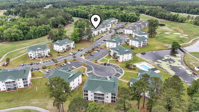 aerial view of a nearby body of water, a golf course, a forest, and apartment complex / building