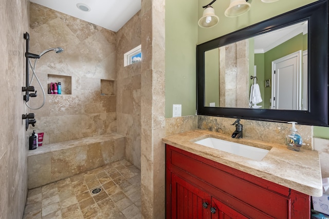 bathroom with a tile shower, vanity, and stone finish floors