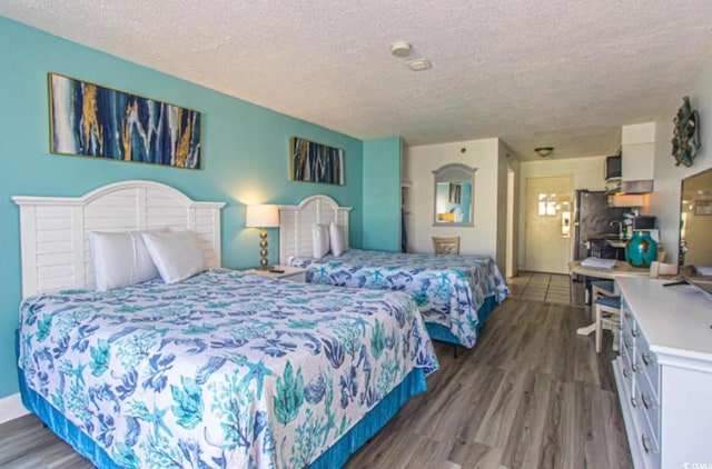 bedroom with a textured ceiling and wood finished floors