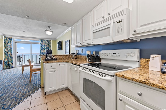 kitchen featuring white appliances, ornamental molding, a textured ceiling, white cabinets, and a peninsula