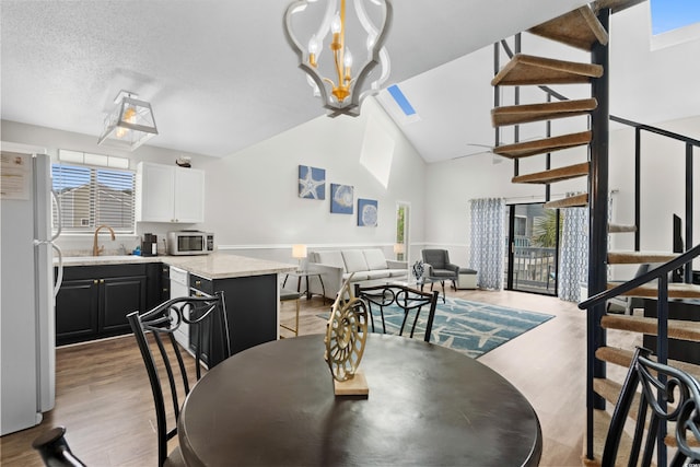1891 Colony Dr Unit 15J, Surfside Beach, SC 29575 - dining area with stairs, light wood-style flooring, a chandelier, and high vaulted ceiling