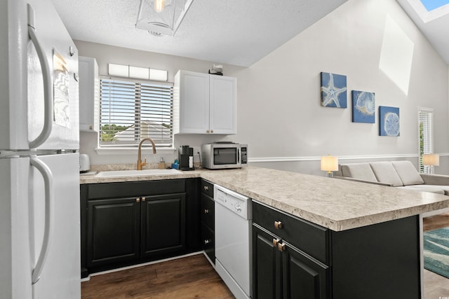 1891 Colony Dr Unit 15J, Surfside Beach, SC 29575 - kitchen featuring white appliances, a peninsula, dark cabinets, a sink, and light countertops