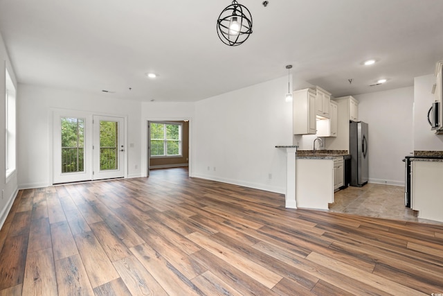 144 Puffin Dr Unit 2A, Pawleys Island, SC 29585 - unfurnished living room with light wood-style floors, a sink, baseboards, and recessed lighting