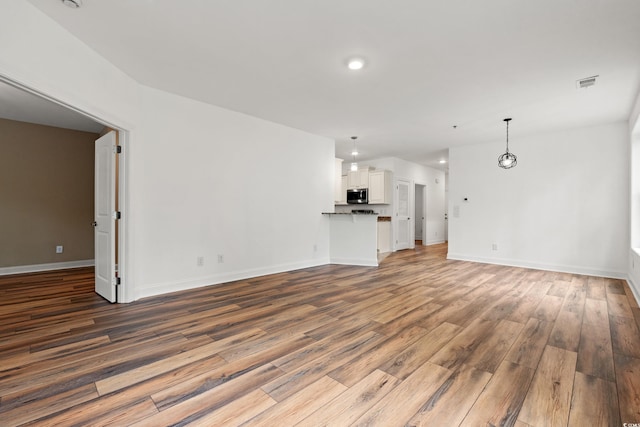 144 Puffin Dr Unit 2A, Pawleys Island, SC 29585 - unfurnished living room featuring wood finished floors, baseboards, and recessed lighting