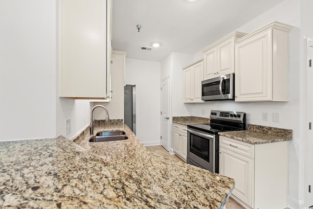 144 Puffin Dr Unit 2A, Pawleys Island, SC 29585 - kitchen with stainless steel appliances, a sink, light stone countertops, baseboards, and recessed lighting