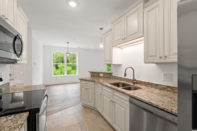 144 Puffin Dr Unit 2A, Pawleys Island, SC 29585 - kitchen with appliances with stainless steel finishes, a sink, light stone countertops, and pendant lighting