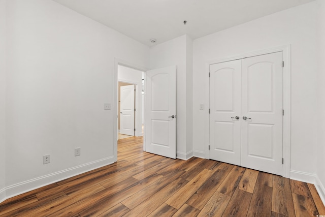 144 Puffin Dr Unit 2A, Pawleys Island, SC 29585 - unfurnished bedroom featuring wood finished floors, baseboards, and a closet