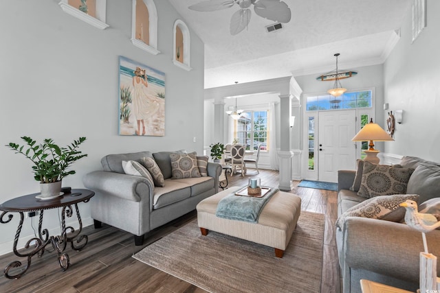 living room featuring ornate columns, wood finished floors, ceiling fan, ornamental molding, and a wainscoted wall