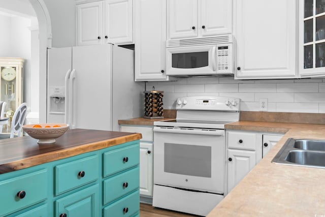 kitchen featuring white appliances, white cabinets, tasteful backsplash, and light countertops