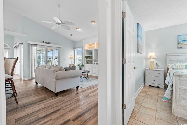 bedroom with lofted ceiling, light wood finished floors, access to exterior, and baseboards