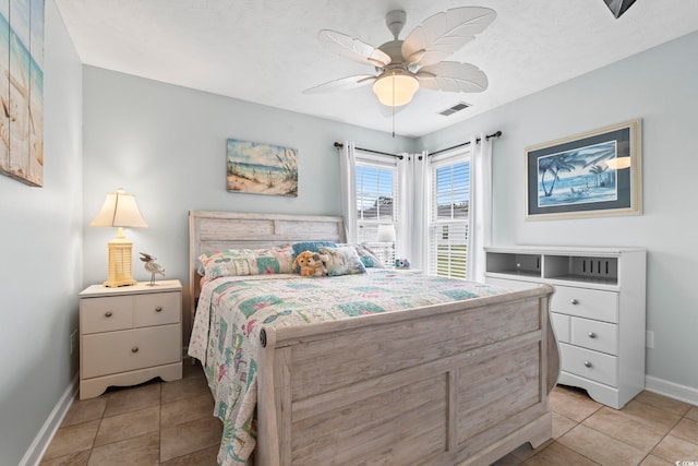 bedroom featuring baseboards, light tile patterned floors, and a ceiling fan