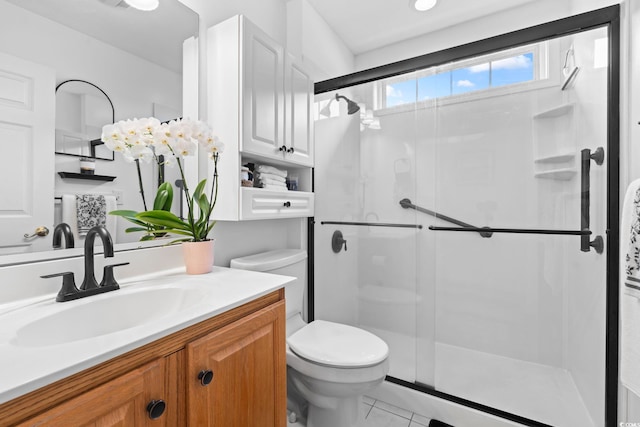 bathroom with toilet, a shower stall, and vanity