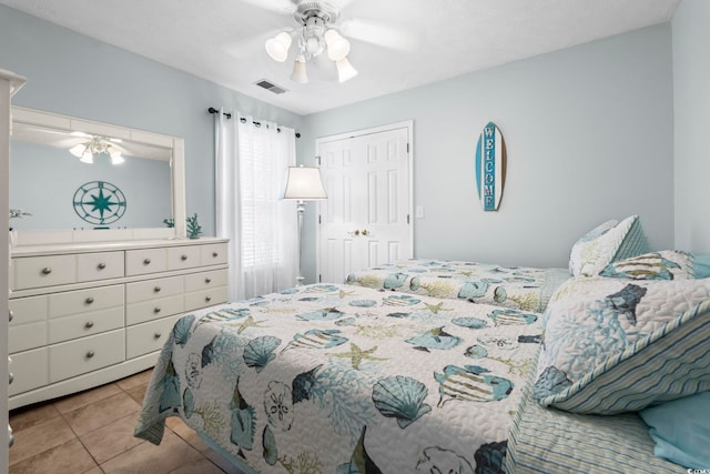 bedroom with tile patterned flooring, a closet, and ceiling fan
