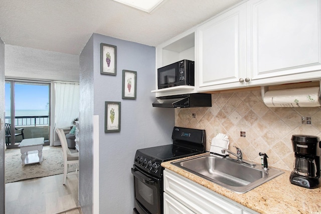 2311 S Ocean Blvd Unit 559, Myrtle Beach, SC 29577 - kitchen with black appliances, a sink, tasteful backsplash, light wood finished floors, and white cabinetry