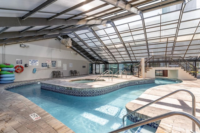 indoor pool featuring a hot tub, a patio area, and stairway