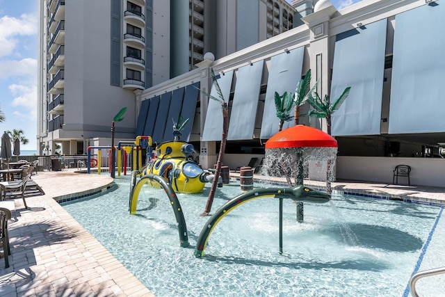 view of swimming pool with a water play area and a patio area