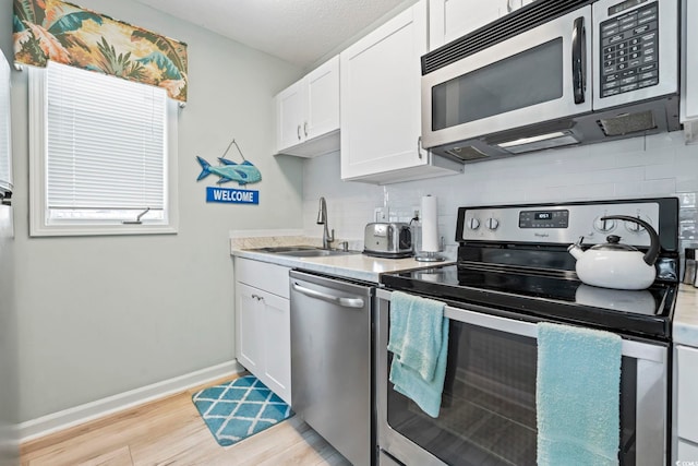 207 Double Eagle Dr Unit F-3, Myrtle Beach, SC 29575 - kitchen with appliances with stainless steel finishes, decorative backsplash, light wood-style flooring, and light countertops
