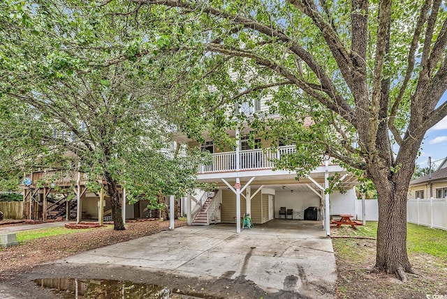view of front of property with stairs, driveway, fence, and a carport