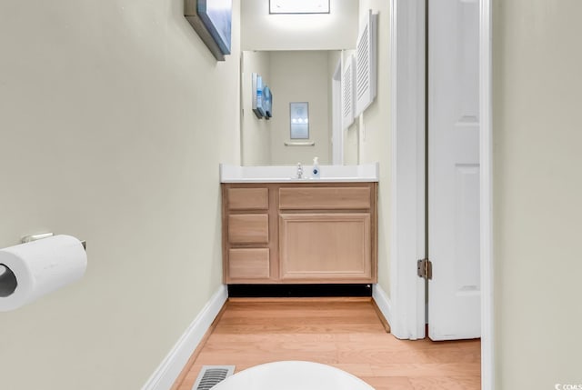bathroom featuring wood finished floors, baseboards, and vanity