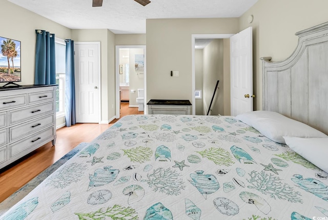 bedroom with light wood-style floors, ensuite bathroom, and a ceiling fan