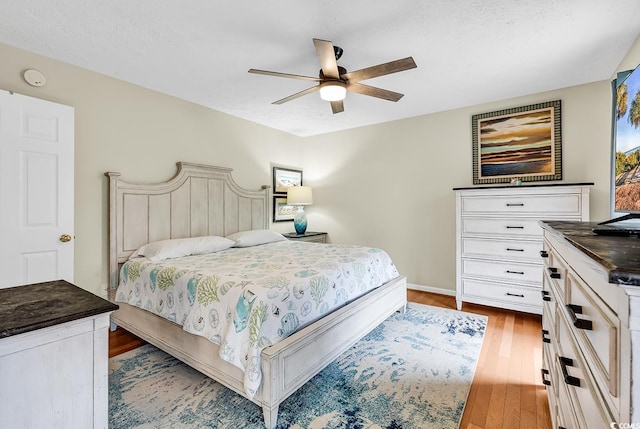 bedroom with wood finished floors, a ceiling fan, and baseboards