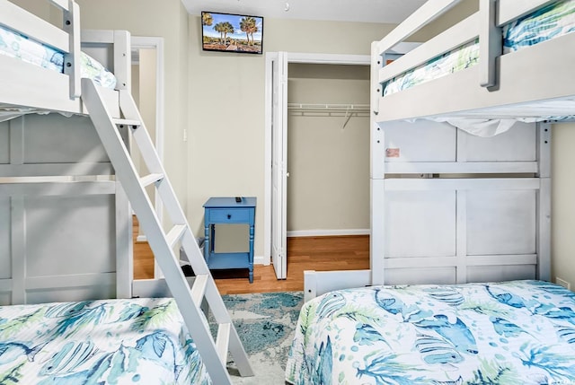 bedroom featuring a closet, wood finished floors, and baseboards