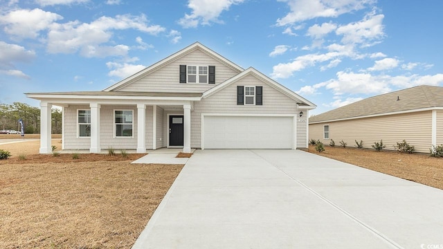 4458 E Coast Ln, Shallotte, NC 28470 - view of front facade featuring driveway, covered porch, and a garage