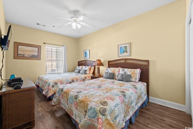 bedroom featuring baseboards, wood finished floors, and ceiling fan