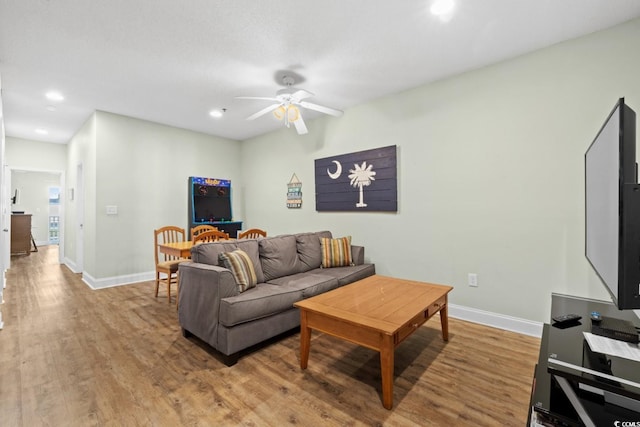 living area featuring ceiling fan, recessed lighting, baseboards, and wood finished floors