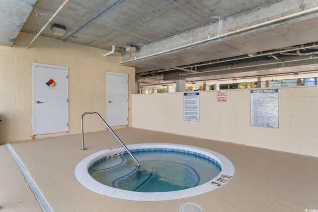 view of swimming pool with an in-ground hot tub