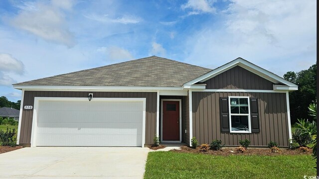 4470 E Coast Ln, Shallotte, NC 28470 - view of front of house featuring a shingled roof, driveway, an attached garage, and a front yard