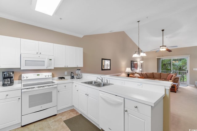 kitchen with white appliances, a sink, a peninsula, open floor plan, and white cabinetry