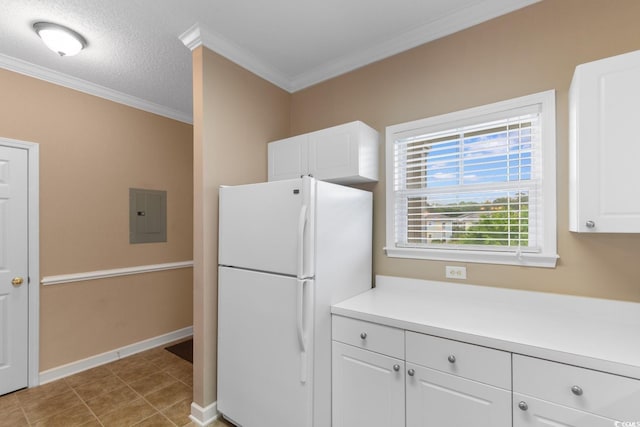 kitchen with freestanding refrigerator, electric panel, crown molding, white cabinetry, and baseboards