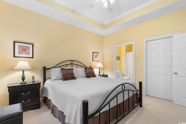 bedroom featuring light carpet, ornamental molding, connected bathroom, and ceiling fan