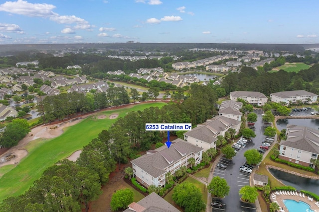 aerial overview of property's location featuring nearby suburban area, a local golf course, and a nearby body of water