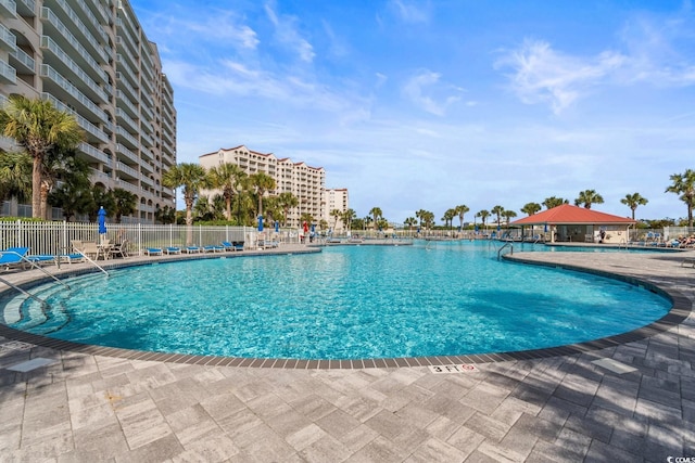 community pool with fence and a patio area