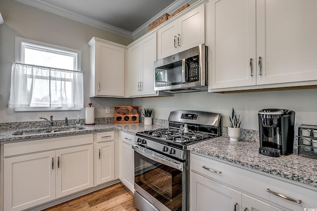 240 Wagner Cir, Conway, SC 29526 - kitchen with stainless steel appliances, a sink, crown molding, white cabinetry, and light stone counters