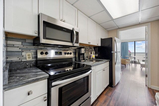 1105 S Ocean Blvd Unit 724, Myrtle Beach, SC 29577 - kitchen with appliances with stainless steel finishes, a sink, backsplash, white cabinetry, and dark wood-type flooring