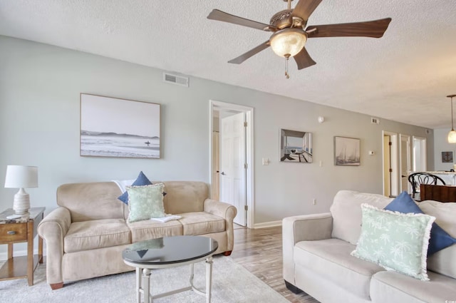 612 N Ocean Blvd Unit 103, Surfside Beach, SC 29575 - living room with a textured ceiling, ceiling fan, wood finished floors, and baseboards