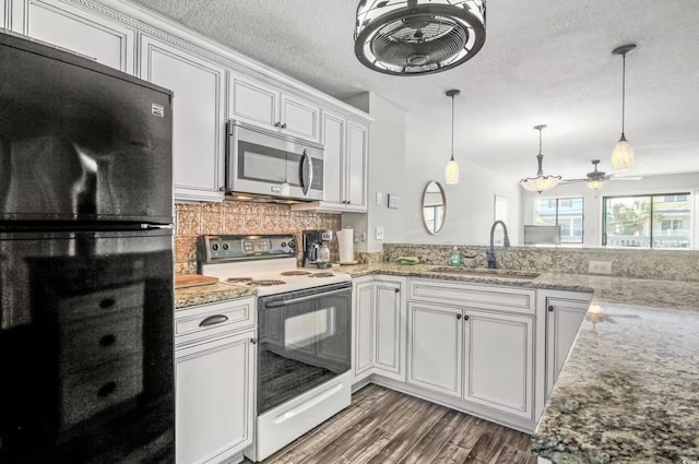 612 N Ocean Blvd Unit 103, Surfside Beach, SC 29575 - kitchen with stainless steel microwave, electric range, freestanding refrigerator, a sink, and wood finished floors
